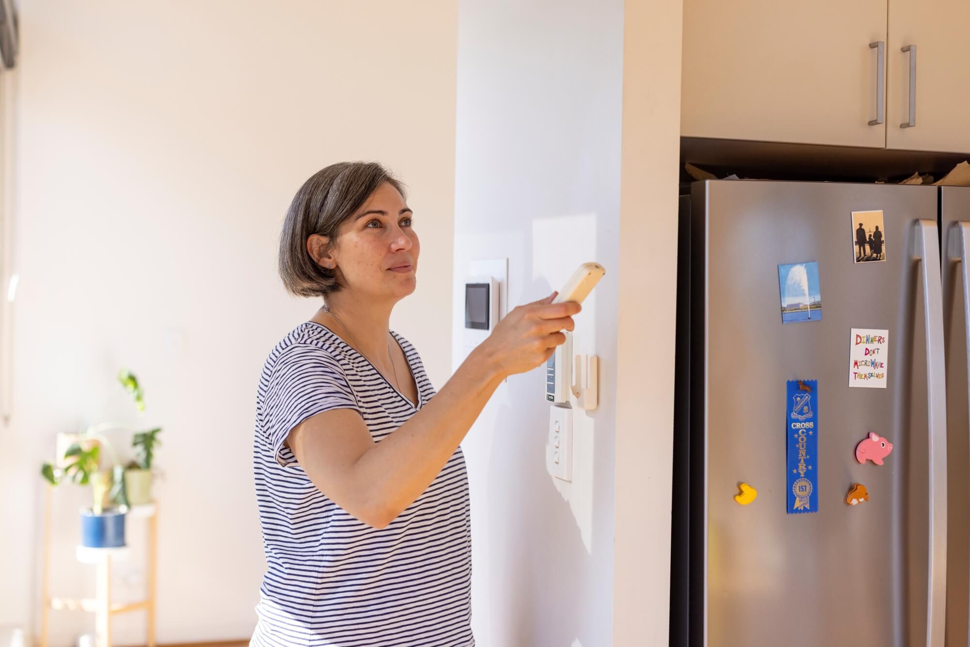A woman operating the air conditioning
